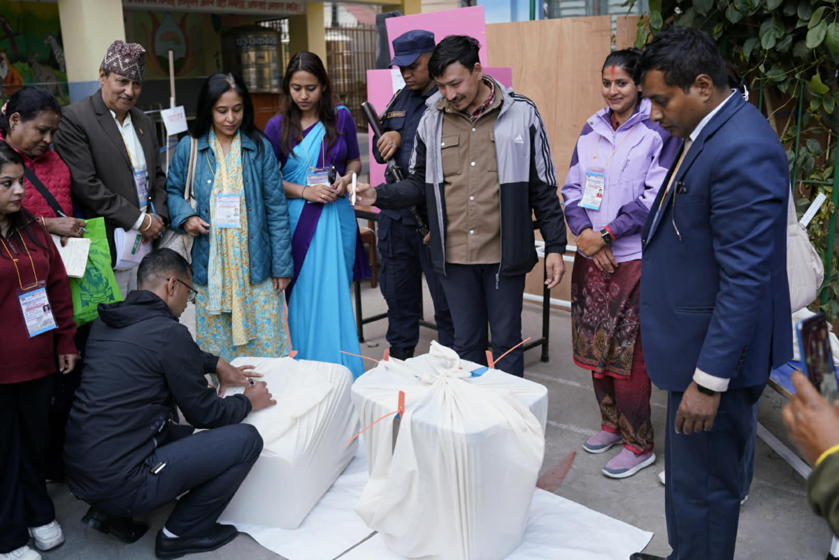 मतदान सम्पन्न भएपछि मतपेटिका सिल गर्दै कर्मचारी र सुरक्षाकर्मी (फोटो फिचर)